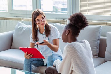 Sağlık ve tıp konsepti. Hastanedeki hasta ve panosu olan ciddi bir doktor. Genç bir doktorun hastaya tablet üzerinde sonuçlar göstermesi