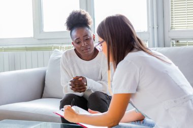 Sağlık ve tıp konsepti. Hastanedeki hasta ve panosu olan ciddi bir doktor. Genç bir doktorun hastaya tablet üzerinde sonuçlar göstermesi