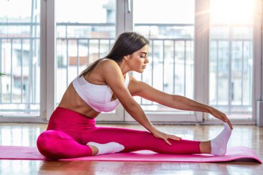 Genç kadının germe yapması bir sağlık kulübü çalışmaları. Kadın fitness mat spor salonunda germe egzersiz yapıyor.