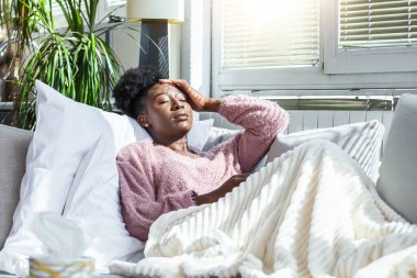 Soğuk ve soğuk algınlığı. Soğuk kapılan, hasta hisseden ve kağıt mendile hapşıran Afrika kökenli Amerikalı kadın portresi. Battaniye Burunlu Güzel Sağlıksız Kız 'a yakın çekim. Sağlık Hizmetleri Konsepti.