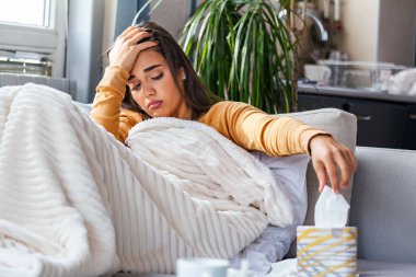 Hasta, çaresiz kadın grip olmuş. Rhinitis, soğuk, hastalık, alerji konsepti. Güzel hasta bir kadının burnu akıyor, burnu mendille sürtüyor. Hapşıran kadın. Esmer mendilin içinde hapşırıyor.