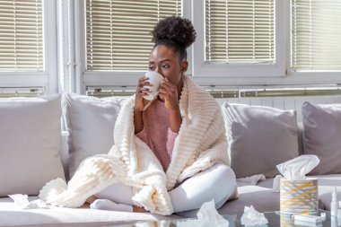 Soğuk ve soğuk algınlığı. Soğuk kapılan, hasta hisseden ve kağıt mendile hapşıran Afrika kökenli Amerikalı kadın portresi. Battaniye Burunlu Güzel Sağlıksız Kız 'a yakın çekim. Sağlık Hizmetleri Konsepti.