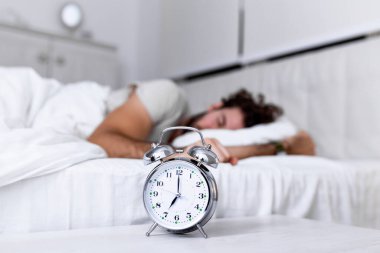 Daha uzun uyu. Sağlık hizmeti konsepti. Uykunun aşamaları. Alarm çaldığı için mutsuz bir adam uyandı. Uyuyor olsan da hiç uyumamış gibi hissedebilirsin..