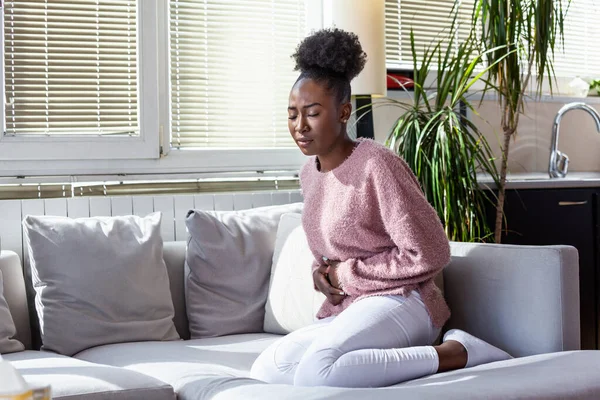 Young Black Woman Suffering Stomachache Sofa Home Woman Sitting Bed — Stok fotoğraf