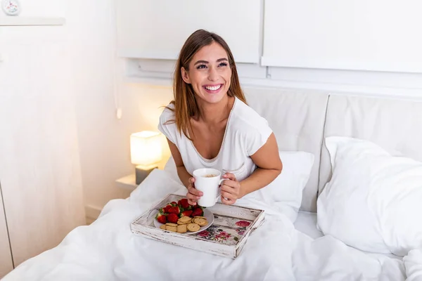 Happy attractive woman woke up in the morning in bed .Good morning and fresh and beautiful breakfast for the girl