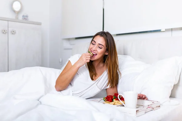 Happy attractive woman woke up in the morning in bed .Good morning and fresh and beautiful breakfast for the girl