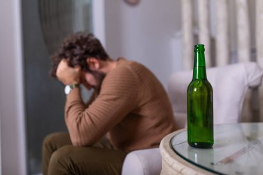Depresyonda olan, kendini kötü hisseden, evde yalnız başına bira içen, alkol bağımlısı, alkolik, alkolik, alkolik, bunalımlı genç bir adam.