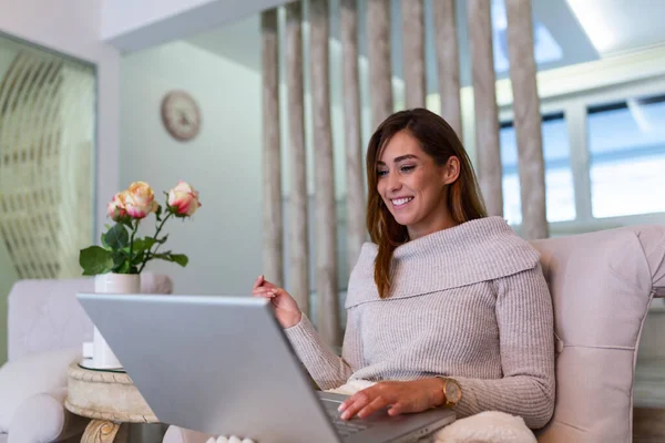 Defterde uzun saçlı güzel bir bayan evdeki kanepeye oturur - pazartesi siber satış için benzin dükkanlarını kontrol eder- alternatif ofis için teknoloji kadını konsepti