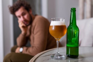 Depresyonda olan, kendini kötü hisseden, evde yalnız başına bira içen, alkol bağımlısı, alkolik, alkolik, alkolik, bunalımlı genç bir adam.