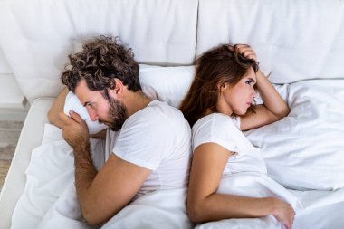 İlişki kavramı. Yatakta yatan genç çiftin en iyi görüntüsü. Yatakta kavga eden bir çift. İlişkiler ve çiftler arasındaki sorunlar hakkında. Cinsel hayal kırıklığı. Aşıklar birbirini görmezden gelir.