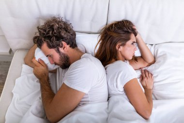 İlişki kavramı. Yatakta yatan genç çiftin en iyi görüntüsü. Yatakta kavga eden bir çift. İlişkiler ve çiftler arasındaki sorunlar hakkında. Cinsel hayal kırıklığı. Aşıklar birbirini görmezden gelir.