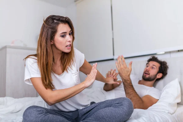 Frustrated sad girlfriend sit on bed think of relationship problems, thoughtful couple after quarrel lost in thoughts, upset lovers consider break up, offended person disappointed by boyfriend
