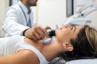 Modern klinikte genç bir kadının ultrason tarayıcısı kullanarak boynunu muayene ettirdiği yakın plan bir fotoğraf.