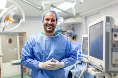 Anesthetist Working In Operating Theatre Wearing Protecive Gear checking monitors while sedating patient before surgical procedure in hospital clipart