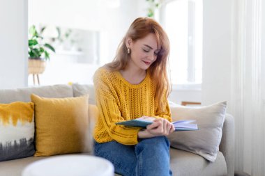 Evdeki nemlendirici. Kanepede kitap okuyan bir kadının yanında.