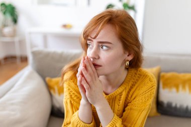 Üzgün kadın çaresizce kanepede oturur pencereden bakar kişisel sorunları düşünür zor bir hayattan çıkış yolu bulamaz. Ayrılma, kalp kırıklığı, aldatılmış kız konsepti