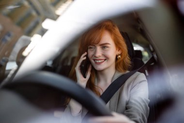 Gezgin Sürücü Kadın 'ın fotoğrafı direksiyon başında akıllı telefondan konuşuyor. Dikkatlice araba kullanmıyor, yol kurallarını çiğniyor. Modern hayatta hızlı ritim kavramı. trafik kurallarını kır