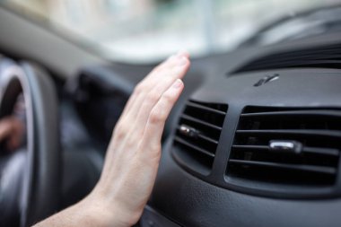 Kadın, arabasının soğutma sistemini ayarlıyor, el şoförünü kapatıyor, soğutma sistemini soğutma sistemini kontrol ediyor, arabasındaki soğuk hava akışını kontrol ediyor..