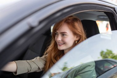 Şirin genç bayan mutlu araba kullanıyor. Araba süren ve gülümseyen güzel bir genç kadın resmi. Emniyet kemeri takan mutlu kadın sürücü portresi.