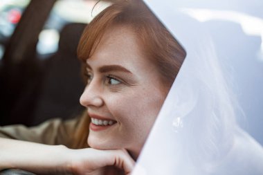 Genç kadın yeni arabasını kucaklıyor. Heyecanlı genç kadın ve yeni arabası içeride. Genç ve neşeli bir kadın yeni arabasının keyfini çıkarıyor.