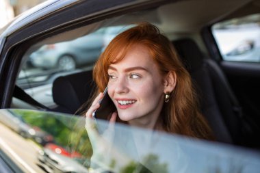 Güzel iş kadını lüks arabasının arka koltuğunda ofisten işe gidip geliyor. Girişimci Yolcu Şehir Caddesinde Taksiyle Seyahat Ediyor