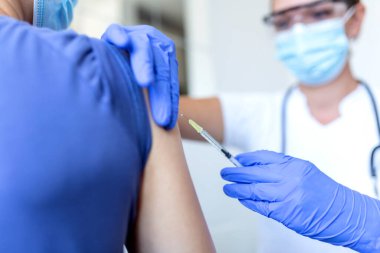 Pratisyen hekimin klinikteki eski hastaya fotokopi alanı aşılaması. Doktor, hastanedeki yaşlı adama iğne yapıyor. Covid-19 ya da koronavirüs aşısı yapmadan önce elinde şırınga tutan hemşire. HPV aşısı