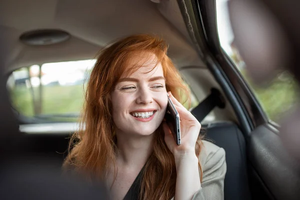 Young girl uses a mobile phone in the car. Technology cell phone isolation. Internet and social media. Woman with smartphone in her car. Girl is using a smartphone in car