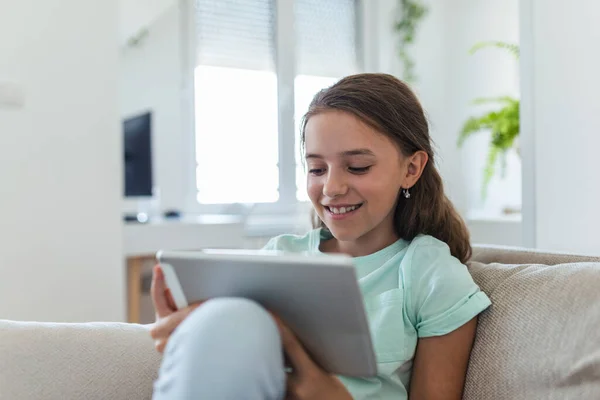 Carino Sorridente Bambina Felice Seduto Sul Divano Utilizzando Cercando Pad — Foto Stock