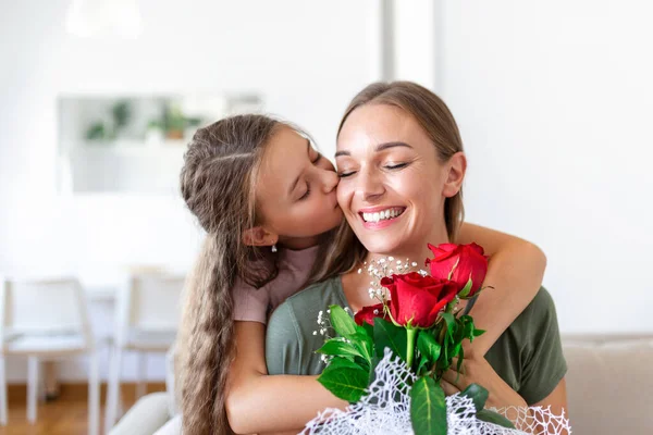 I love my you mom! Attractive young woman with little cute girl are spending time together at home, thanking for handmade card with love symbol and flowers. Happy family concept. Mother\'s day.