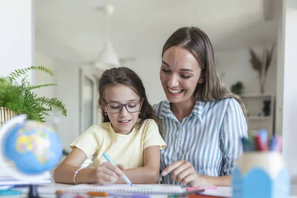 Little girl coloring picture in album during staying at home with mother, widescreen. Generation and happy family concept