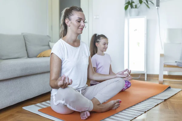 family mother and child daughter are engaged in fitness, yoga, exercise at home. mother and daughter practicing yoga