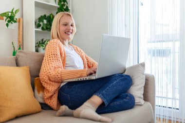 Young woman on a video call from home with her friends while in quarantine. Cropped shot of an attractive young woman using her laptop to make a video call at home