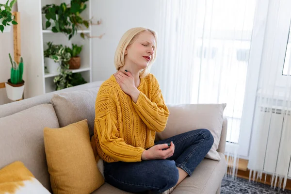 Pain in the shoulder. Upper arm pain, People with body-muscles problem, Healthcare And Medicine concept. Attractive woman sitting on the bed and holding painful shoulder with another hand.