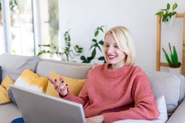 Uśmiechnięta Młoda Kobieta Używająca Laptopa Domu Patrząca Ekran Rozmawiająca Nosząca — Zdjęcie stockowe