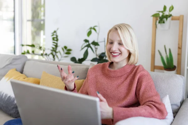 Young woman on a video call from home with her friends while in quarantine. Cropped shot of an attractive young woman using her laptop to make a video call at home