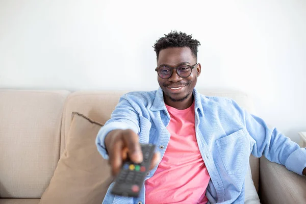 Excited African American Man Pointing Television Controller To Camera Switching Channels Watching TV . Television Programming Advertisement. Selective Focus