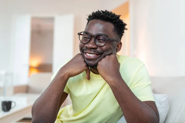 Profile picture of smiling young African American man in glasses pose in own home apartment. Close up headshot portrait of happy millennial biracial male renter or tenant in spectacles show optimism.