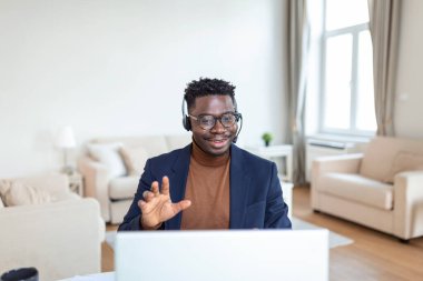 Heyecanlı Afro-Amerikalı adam kulaklık takıyor e-postada iyi haberler okuyor, yeni bir işe giriyor, terfi ediyor, dizüstü bilgisayar kullanıyor, ekrana bakıyor ve neşeyle bağırıyor, evet işareti yapıyor, kutluyor.