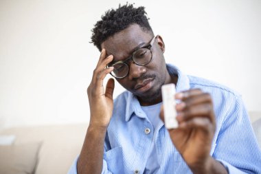 Genç Afrikalı adam pozitif Coronavirüs taşıyor. Covid-19 hızlı test. Genç Afrikalı Amerikalı adam evinde antijen teçhizatıyla COVID-19 testi yaptırıyor..