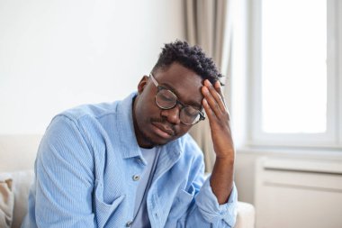 Kronik baş ağrısı çeken genç bir adam, online tedavi, tıbbi konsültasyon randevusu, elektromanyetik radyasyon, hastalık maaşı