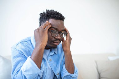 Kronik baş ağrısı çeken genç bir adam, online tedavi, tıbbi konsültasyon randevusu, elektromanyetik radyasyon, hastalık maaşı