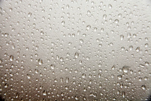 Gotas de lluvia cayendo sobre vidrio — Foto de Stock