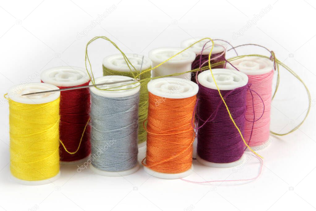 various colors of thread and sewing needle