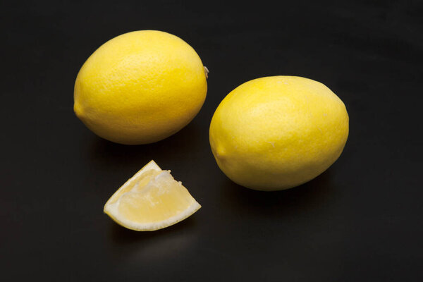 Fresh yellow lemons on a black background