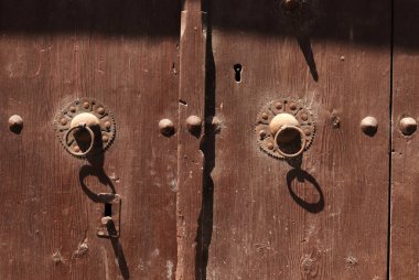Rusty old knocker on weathered wooden door