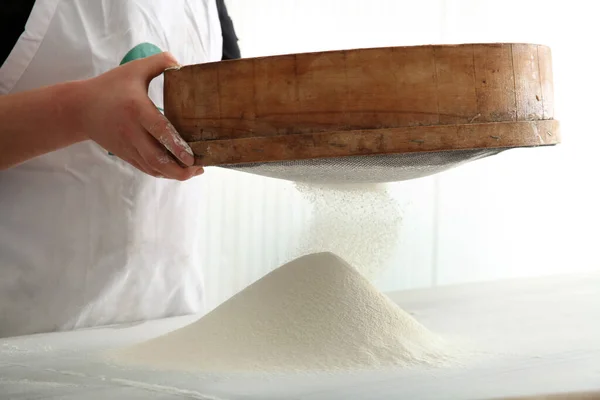 パン作りのために小麦粉をふるいにかけるシェフ — ストック写真