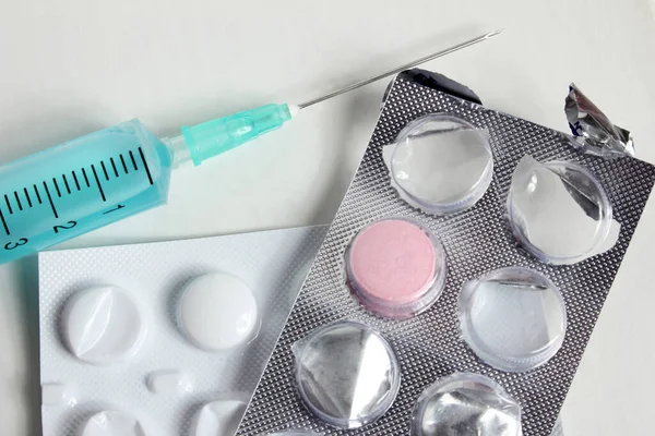 Pink color pill and syringe. Medical background.
