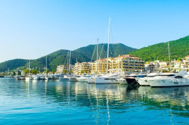 Tivat, Karadağ - 28 Haziran 2021: Porto Karadağ 'daki yat marinasının deniz kenarındaki konutları ve güzel gezinti alanlarıyla gün batımı manzarası
