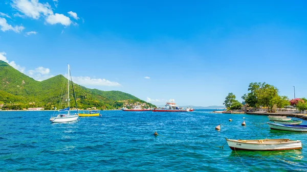 Kotor, Karadağ - 22 Ağustos 2021: Kotor Körfezi kıyı şeridinin güzel yaz manzarası - Boka Körfezi 'nde arka planda tekne ve dağ manzarası
