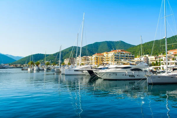 Tivat, Karadağ - 28 Haziran 2021: Porto Karadağ 'daki yat marinasının deniz kenarındaki konutları ve güzel gezinti alanlarıyla gün batımı manzarası
